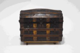 A wooden and metal bound domed trunk, with metal crocodile skin effect panels, interior tray,