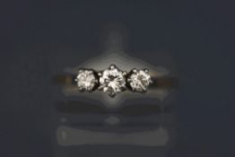 A three stone diamond ring, unmarked, the graduated brilliant cuts totalling approximately 0.