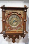 An Arts and Crafts oak cased wall clock, with decorative brass mounts,
