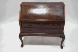 A mahogany bureau on stand, with fall front above two long drawers,