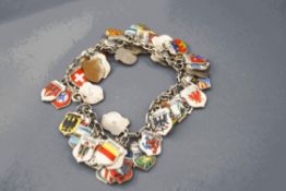 A bracelet of continental enamel souvenir charms, of shield shape bearing town/city coats of arms,