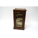 A Victorian walnut music cabinet with marquetry inlay and brass gallery above a glazed door on a
