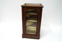 A Victorian walnut music cabinet with marquetry inlay and brass gallery above a glazed door on a