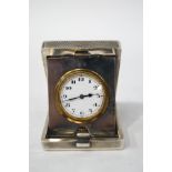 A silver folding travel clock in engine turned case, by A. Nicholls and Son, Birmingham 1928, 6.