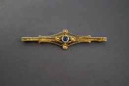 A sapphire and seed pearl bar brooch, stamped '15ct', 5 cm long, 3.