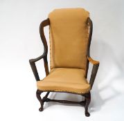 An early 18th century wing armchair with covers, partially restored with cabriole legs,