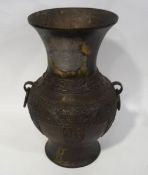 A Japanese bronze urn with flared neck and two ring handles,