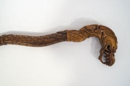 An Indonesian carved staff, the handle carved with a dragon's head, 120.
