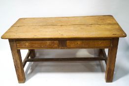 A large pine kitchen table with two frieze drawers, on square legs, linked with stretchers,