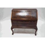 A mahogany bureau on stand, with fall front above two long drawers,