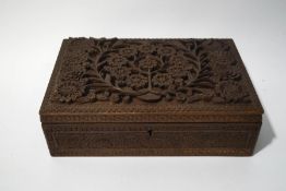 An Anglo Indian box, the cover carved and pierced with scrolling flowers,