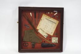 Various button hooks, buckles, advertisements, buttons and other items, within a mahogany box frame,