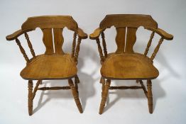 A pair of smokers bow style chairs with pierced shaped splats, solid seats and turned legs,