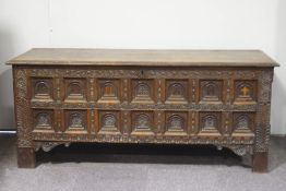 A 17th century style Continental coffer, the front inset with fourteen carved and inlaid panels,