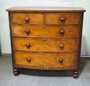 A Victorian mahogany bow fronted chest of two short and three long drawers with turned handles and