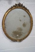 A Victorian oval wall mirror, the gilt plaster frame crested with acorns, berries and leaves,