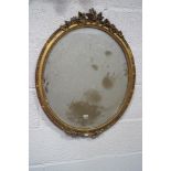 A Victorian oval wall mirror, the gilt plaster frame crested with acorns, berries and leaves,