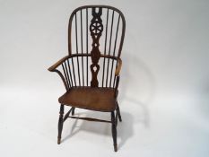 A 19th century Windsor elbow chair with pierced splat, the solid seat with old blacksmith's repair.