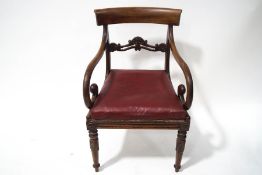 A William IV mahogany yoke back scroll arm elbow chair having a carved bar back,