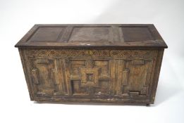 A 17th century Continental oak coffer with later triple panelled top,