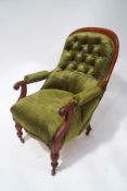 A Victorian mahogany framed button back armchair on turned legs with ceramic casters