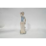 A Tengra figure of a young lady holding the hem of her skirt, decorated in Lladro style,