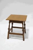 A square oak table, on turned legs, linked by rectangular stretchers,