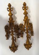 A pair of wall hanging two branch candlesticks, moulded with fruit scrolls and leaves, gold painted,