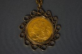 A 1915 Sovereign, in a 9 carat gold scroll edge pendant mount, on a chain,