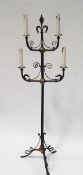 A wrought iron four branch candlestand, with fleur de lys design, converted to electricity,
