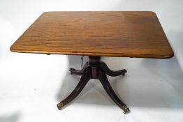A 19th century mahogany breakfast table with tilt top on turned baluster supports of four splayed