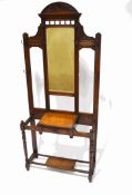 An Edwardian mahogany hall stand with eight hooks, flanking a mirror above one drawer,
