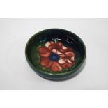 A Moorcroft bowl, tube lined with a flowerhead on a green ground,