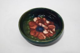 A Moorcroft bowl, tube lined with a flowerhead on a green ground,