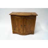 A pine standing cupboard with serpentine top above two panelled doors on shaped plinth base, 78.