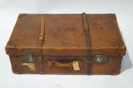 A vintage leather steamer trunk with black interior, including a drop-in tray and clasped pouch,