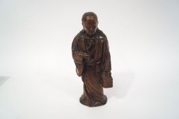 A 20th century Japanese carved figure in traditional dress, carrying a basket,