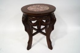 A 20th century continental occasional table, with inset marble top on four carved legs,