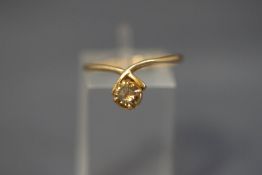 A gold and cognac diamond single stone ring, un-marked, the brilliant cut of approximately 0.