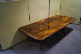 A Regency style mahogany cross banded dining table with two turned pedestals,