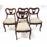 A set of four Victorian rosewood dining chairs with kidney shaped backs and flower carved detail,