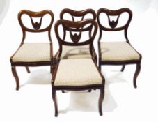 A set of four Victorian rosewood dining chairs with kidney shaped backs and flower carved detail,