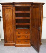 A Victorian mahogany breakfront triple wardrobe with one mirrored door opening to reveal four