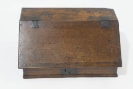 A Charles I oak ledger desk, the fall front on iron hinges enclosing shelves over five drawers,