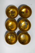 A set of six lacquered bowls, each painted with different figures on a gilt ground,