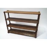 A 19th century oak four tier standing bookshelf with barley twist supports on bun feet,