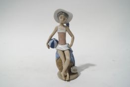 A Lladro porcelain figure of a young girl holding a beach ball, printed factory marks,