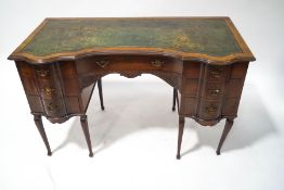 An Edwardian mahogany ladies writing desk with green leather inset top over an arrangement of seven