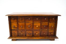 A mahogany spice cupboard with eighteen drawers, each with turned handles on bracket feet,