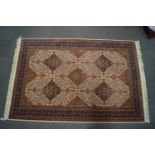 A Persian style carpet with repeating medallions to the central field, upon a neutral ground,